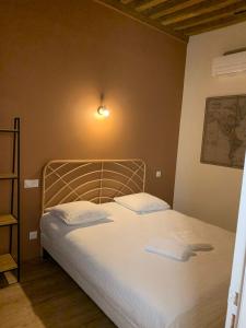 een slaapkamer met een bed met twee handdoeken erop bij Hôtel Des Docks in Digoin