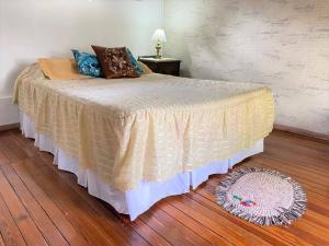 un letto in una camera da letto con pavimento in legno di Botánica! Casa restaurada a Villa Ballester