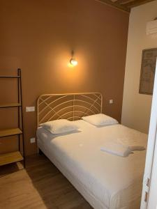 een slaapkamer met een bed en een lampje aan de muur bij Hôtel Des Docks in Digoin