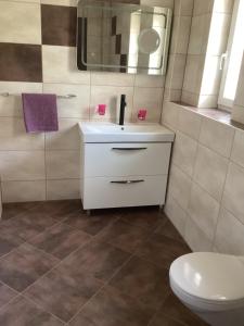 a bathroom with a white sink and a toilet at Apartments Ploka in Trogir