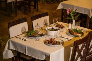 einen Tisch mit Teller mit Speisen darüber in der Unterkunft Kibala Hotel in Cıralı