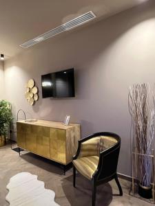 a room with a tv and a chair and a cabinet at Hotel Motel Top in Cusago