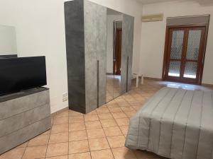 a room with a bed and a flat screen tv at A Casa di Luca in Campagna