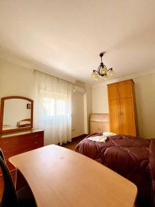 a bedroom with a bed and a mirror and a table at 3Bedroom next to Downtown Mall New Cairo in Cairo