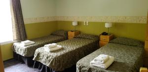 a hotel room with three beds with towels on them at Hotel Geminis in Mendoza +14 photos