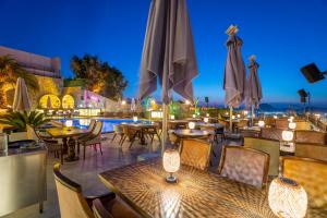 a restaurant with tables and umbrellas at night at Bombien Luxury in Bodrum City