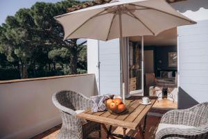 einen Tisch mit einem Sonnenschirm und einer Schale Obst in der Unterkunft La Villa d'Andrea in Ramatuelle