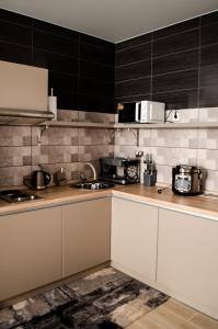 a kitchen with white cabinets and a microwave at Гостьовий Будинок Апартаменти в тихому центральному районі Полтави Смарт-квартири in Poltava