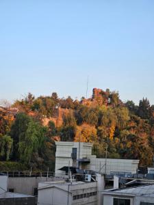 a building on top of a hill with trees at San Ignacio Suite Apartments in Santiago