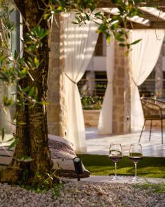 zwei Gläser Wein neben einem Baum in der Unterkunft Traumwohnung in Bardolino mit Pool in Bardolino