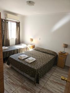 een hotelkamer met 2 bedden en een raam bij Hotel Geminis in Mendoza
