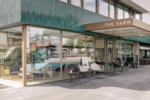 霍根的住宿－The Yarn，大楼前方的商店,配有桌椅