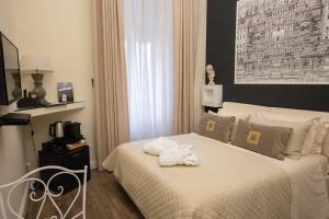 - une chambre avec un lit et des serviettes dans l'établissement Domus Deorum Deluxe, à Naples