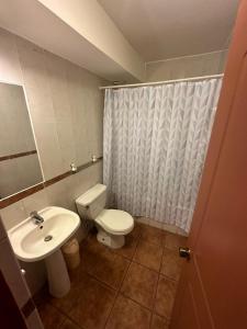 La salle de bains est pourvue d'un lavabo et d'un rideau de douche. dans l'établissement Duna Apart Hotel, à Copiapó