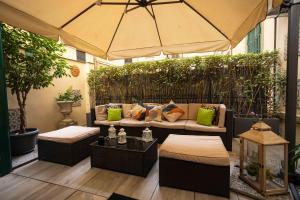 a patio with a couch and an umbrella at Domus Deorum Deluxe in Naples