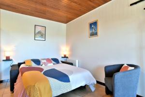 um quarto com uma cama e 2 cadeiras em Gîte de la Bosse Besnard em Saint-Marcan