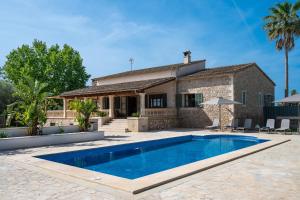 a villa with a swimming pool in front of a house at FINCA MANACOR in Manacor