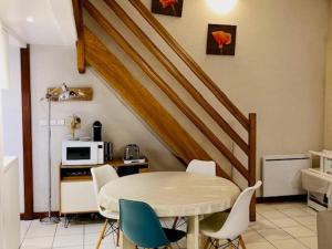 uma cozinha com uma mesa e cadeiras e um micro-ondas em Appartement Saint-Martin-de-Ré, 3 pièces, 4 personnes - FR-1-544-10 em Saint-Martin-de-Ré