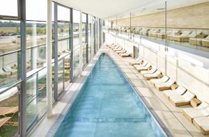 塔亚河畔拉镇Therme Laa Hotel Silent Spa Villas的一个带躺椅的室内游泳池和游泳池