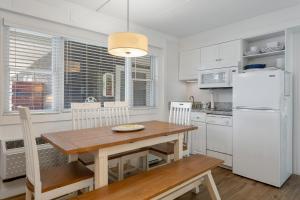 een keuken met een houten tafel en een witte koelkast bij Beachcomber Resort in Avalon