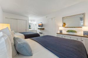 1 dormitorio con 2 camas y espejo en Beachcomber Resort en Avalon