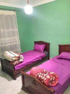 2 camas en una habitación con sábanas moradas en 2 bedrooms apartement at El Marsa 200 m away from the beach with sea view furnished balcony and wifi, en El Marsa