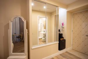 a hallway with a large mirror and a bathroom at Domus Deorum Deluxe in Naples