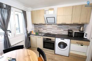 a kitchen with a washer and dryer and a table at Alex 04 in Orşova