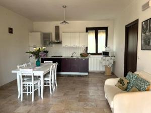 Il comprend une cuisine et un salon avec une table et un canapé. dans l'établissement Villa Giada, à Francavilla Fontana