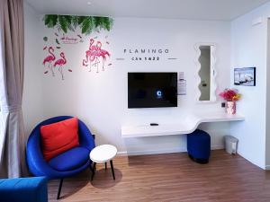 uma sala de estar com uma cadeira azul e uma televisão em Flamigo Ibiza Hải Tiến Tầng 16 em Nam Khê