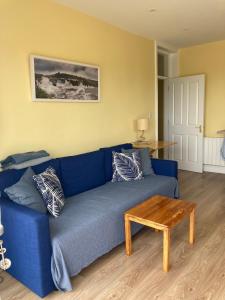 a blue couch in a living room with a table at Beautiful one bed apartment with stunning sea view in Waterford
