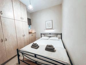 um pequeno quarto com uma cama com toalhas em Dear_Jo_Guesthouse em Vathý