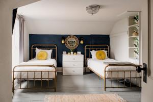 two beds in a bedroom with blue walls at The Paige By Tanglewood Getaways in Pepin