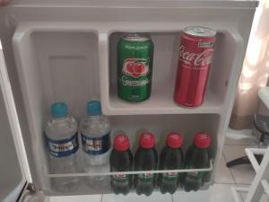 einen Kühlschrank mit Flaschen Soda und Cola in der Unterkunft AP da Cris cabo frio in Cabo Frio
