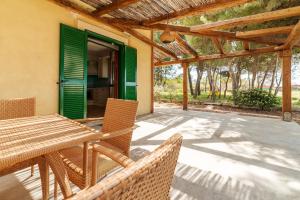 a patio with a table and chairs and a green door at Villa Moscariello - Beach & Sea in Ascea