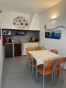 una cucina e una sala da pranzo con tavolo e sedie di Domo Acabara ad Alghero