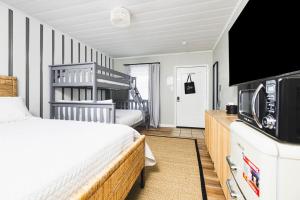 Schlafzimmer mit einem Bett und einem Flachbild-TV in der Unterkunft Seabirds Motel At Kure Beach in Kure Beach