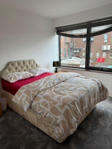 een bed in een slaapkamer met een groot raam bij Paradise - Away - From - Home in Bracknell