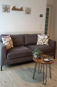 - un canapé brun dans le salon avec une table dans l'établissement CASA Chloe', à Lido di Jesolo