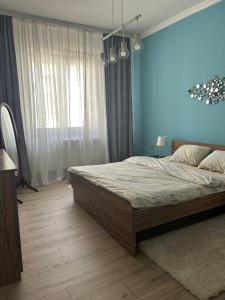 a bedroom with a large bed and a blue wall at Apartman Tara in Subotica +32 photos