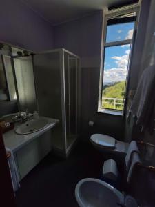 baño con 2 lavabos y ventana en Hotel Panoramico lago d'Orta en Madonna del Sasso