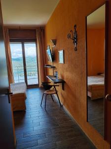 Habitación con espejo, escritorio y ventana. en Hotel Panoramico lago d'Orta en Madonna del Sasso