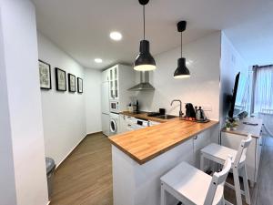 una cucina con lavandino e bancone con due sedie di The eighth wonder! Views and location a Benalmádena