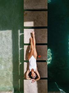 een vrouw ligt aan de rand van een zwembad bij Amalen Suites Adults Only in Rethimnon