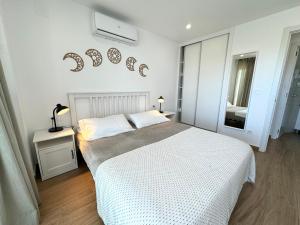 una camera da letto bianca con un letto e una finestra di The eighth wonder! Views and location a Benalmádena Altre 18 foto