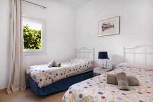 a bedroom with two beds and a window at Villa Amura - Solo Familias in Conil de la Frontera +19 photos