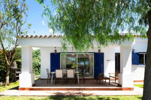 a house with blue doors and a patio at Villa Amura - Solo Familias in Conil de la Frontera