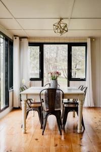 a dining room with a white table and chairs at The Paige By Tanglewood Getaways in Pepin