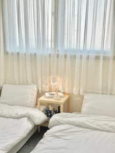 Zimmer mit 2 Betten und einem Tisch mit Fenster in der Unterkunft Stay, LoveLEE in Seoul