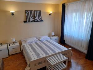 a bedroom with a large bed and a window at Rooms Margarita in Zadar